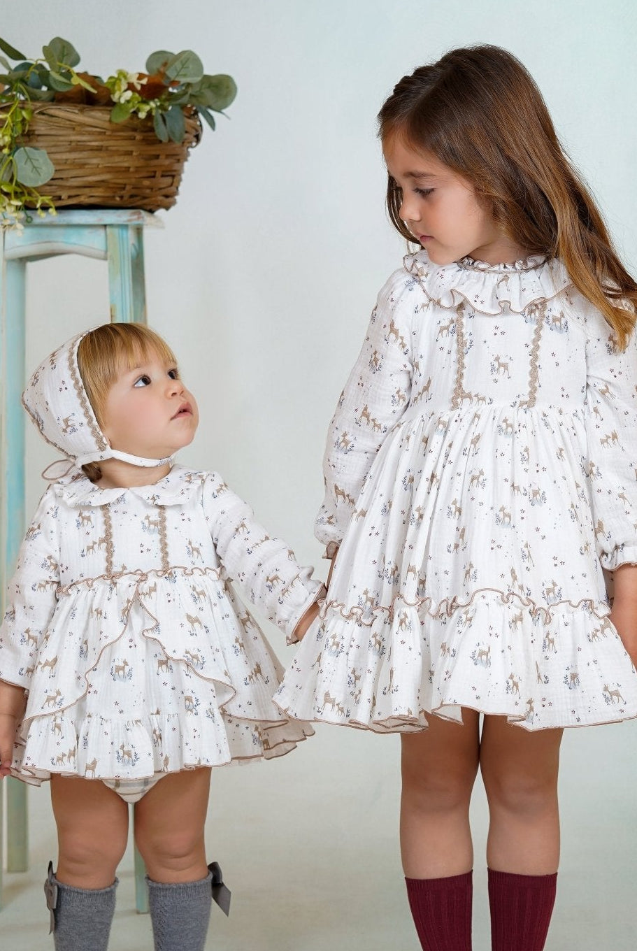 Girl wearing a long-sleeved deer print dress with ruffled collar and hem from DBB Collection AW25.