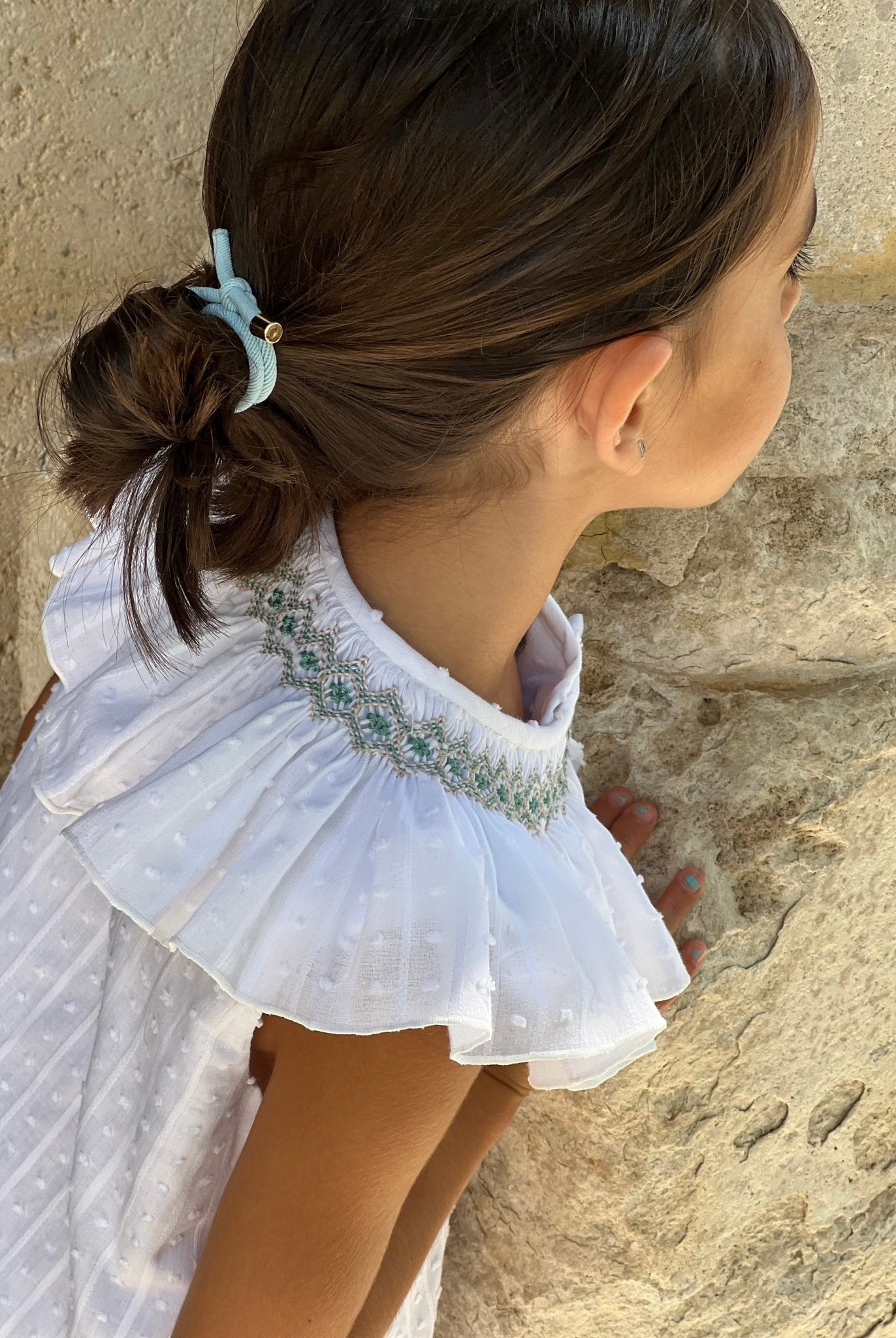 Young child wearing El Copo SS2 white Summer Dress with smocked statement collar detail.