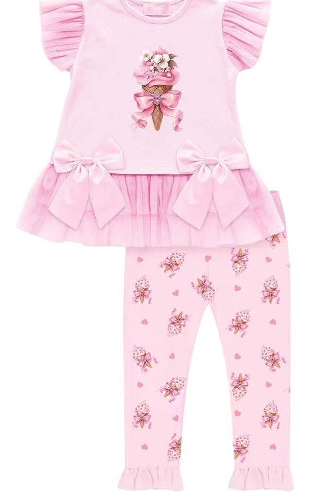 Pink children's outfit with ruffled top and floral pants on a white background