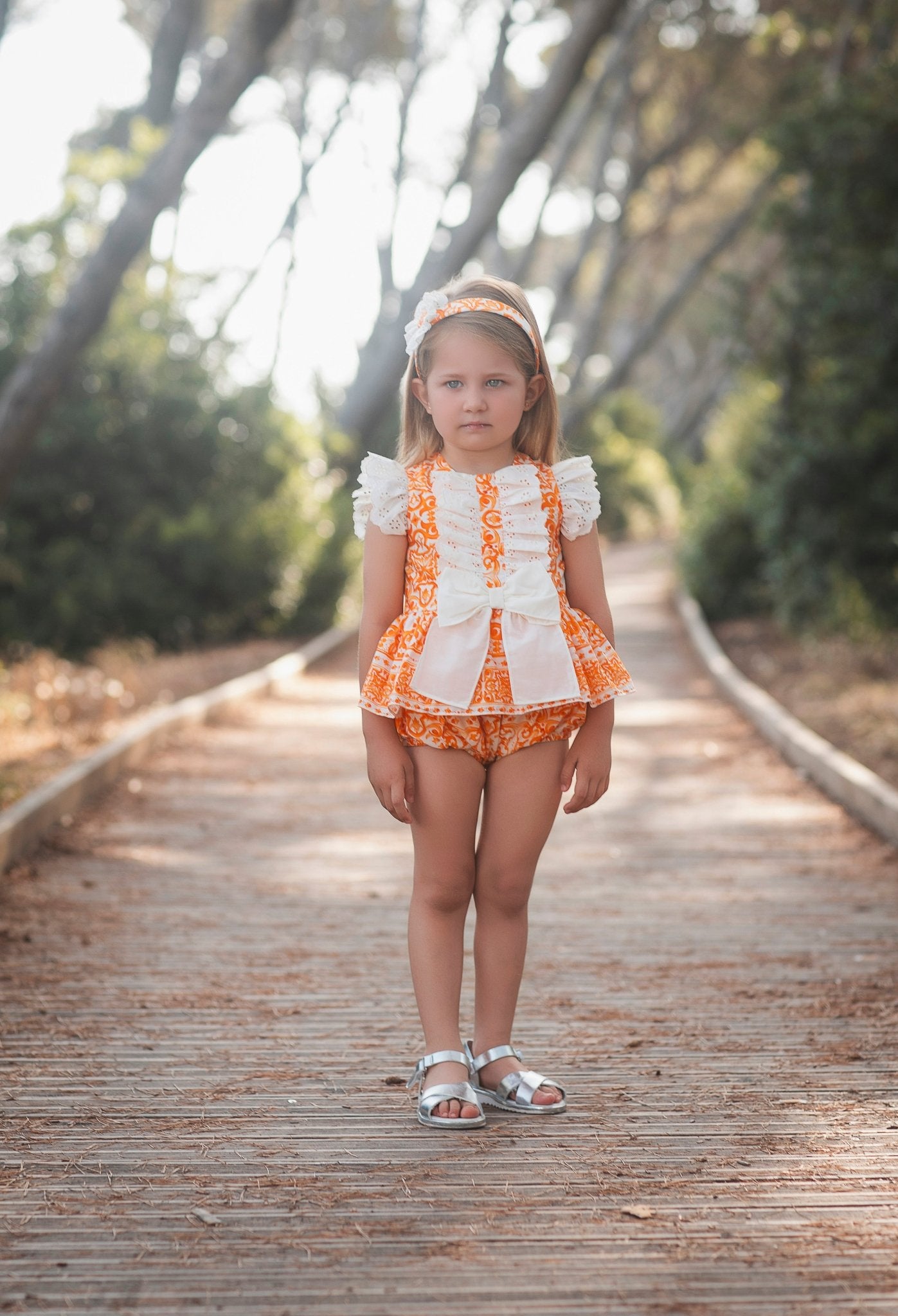 Little girl wearing Rochy SS26 Orange D&G Print Bloomer shorts Set.