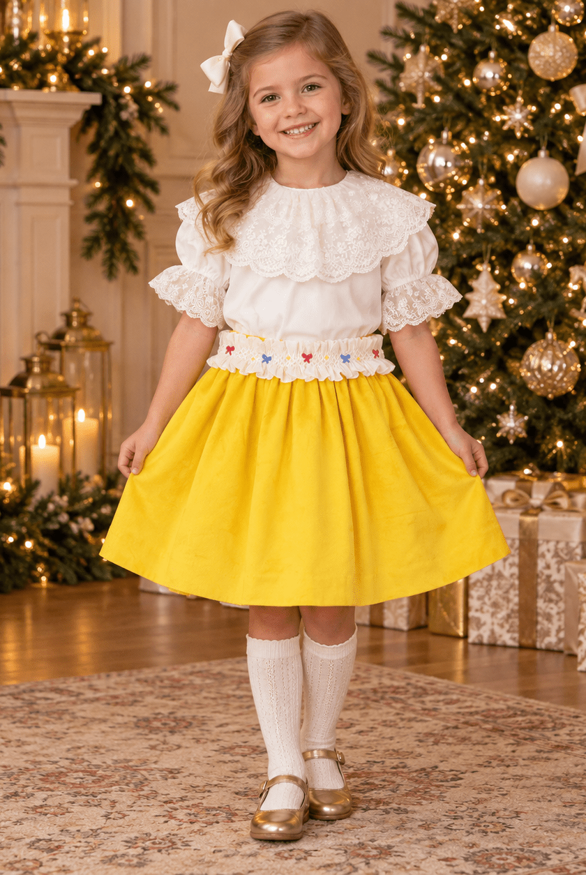 Golden Smocked Skirt Set by Sal & Pimenta modelled by a young girl in a christmas decorated living room.
