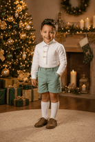 Abuela Tata boys green shorts and ivory shirt set for AW26 Spanish childrenswear young boy with christmas background