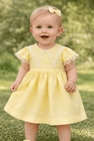 Basmarti baby girls lemon yellow dress with lace collar detail, Spanish linen cotton dress for Easter and summer from the SS26 collection.