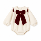 An off-white long-sleeve baby bodysuit featuring a large dark red velvet bow and matching trim on the collar, displayed against a solid white background.