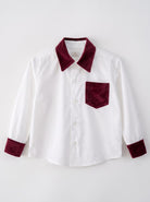 A white long-sleeve button-up shirt with contrasting deep burgundy velvet collar, cuffs, and a matching chest pocket, displayed flat against a light gray background.