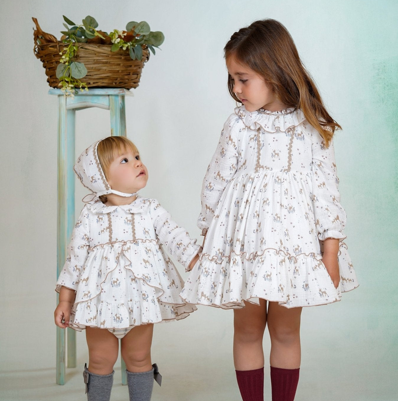 Girl wearing a long-sleeved deer print dress with ruffled collar and hem from DBB Collection AW25.