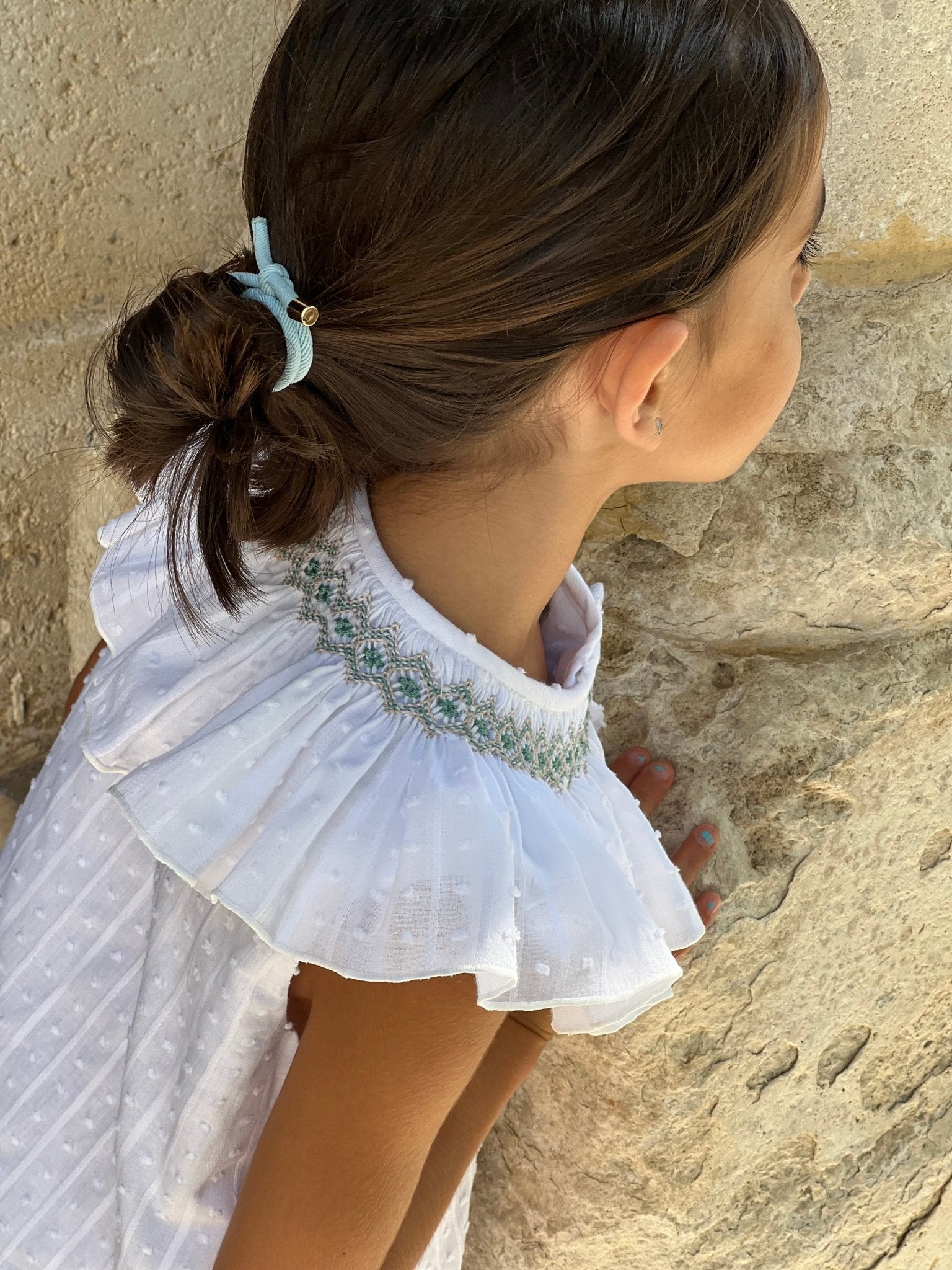 Young child wearing El Copo SS2 white Summer Dress with smocked statement collar detail. 