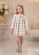 Girls Rochy Cream, Gold and Camel Dress on a child model standing in a luxury room. 