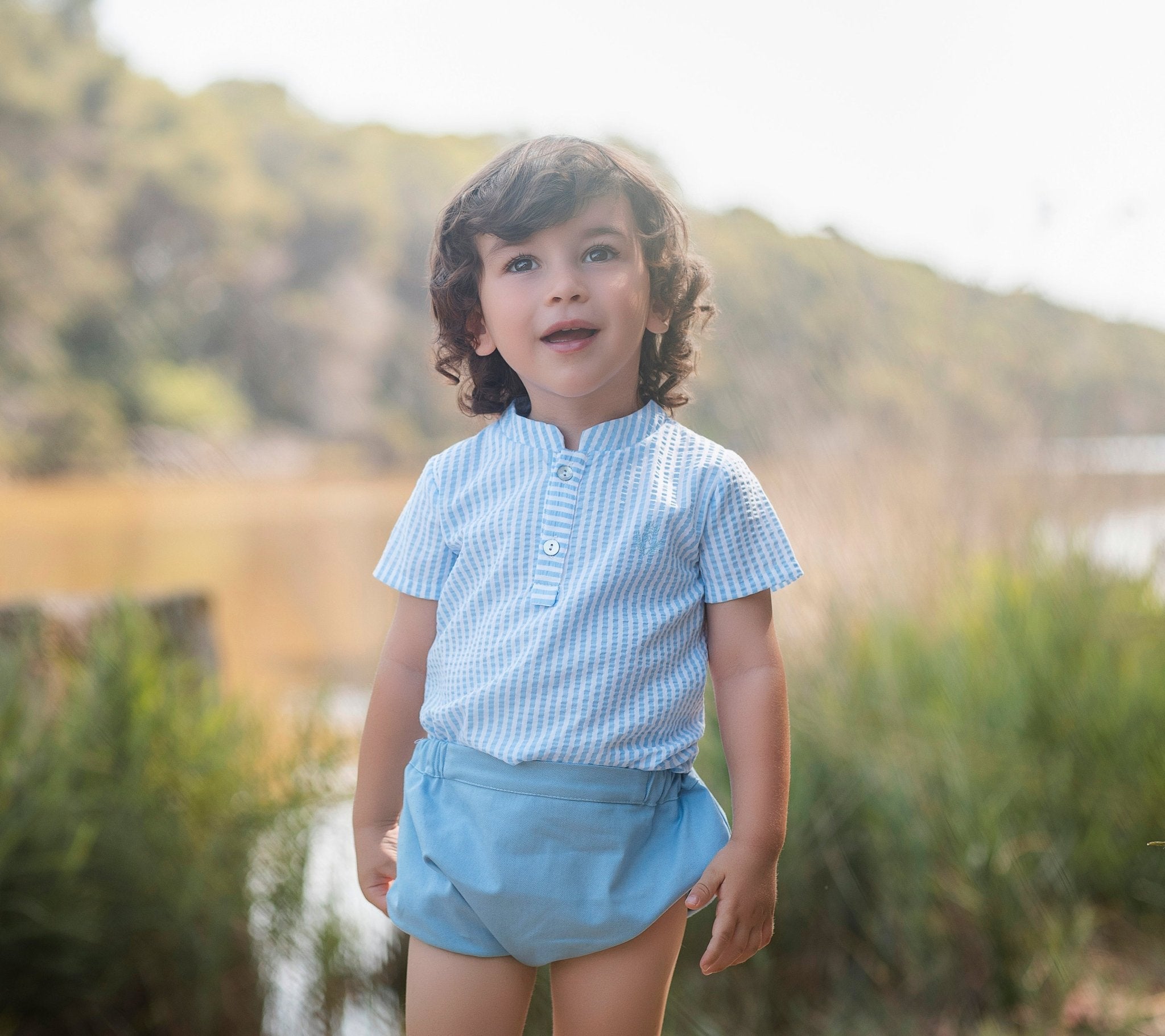 Little boy wearing Rochy SS26 Baby Blue Shorts & Shirt Set. 