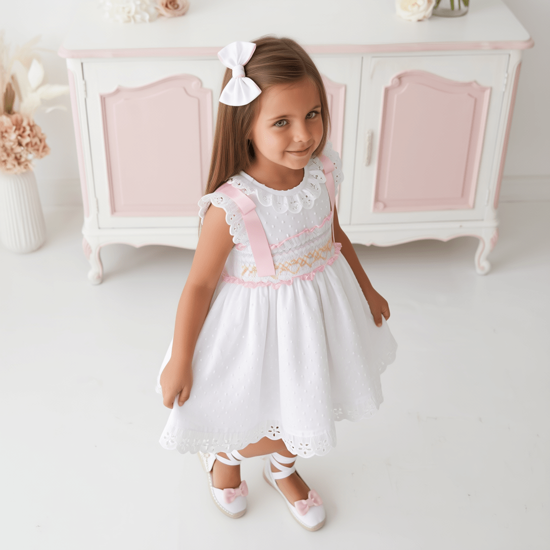 Girls white smocked Spanish dress with pink ribbon detail, broderie anglaise trims and full skirt